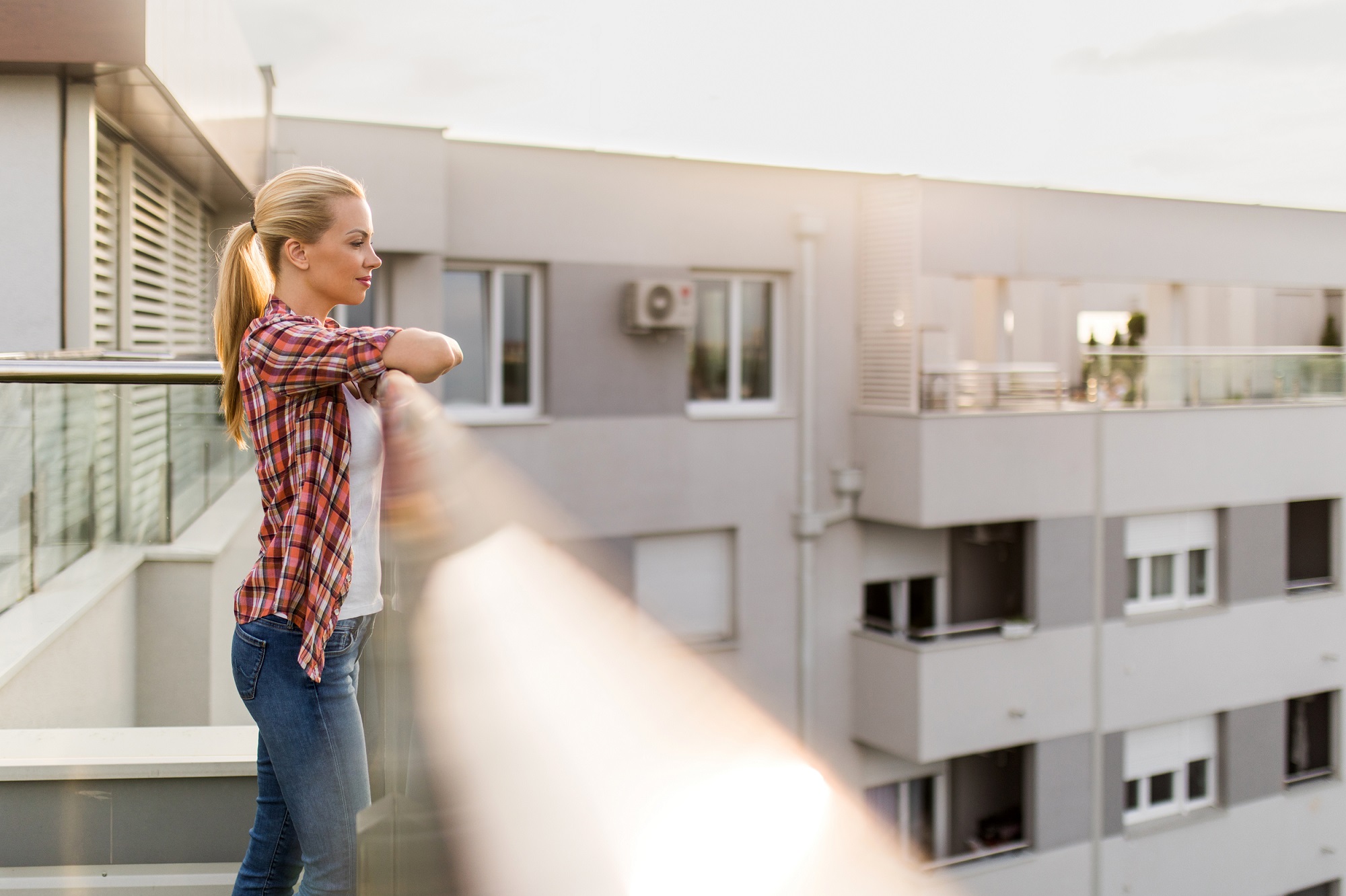 Young woman enjoying in sunny day on her penthouse balcony. CTS Immobilien